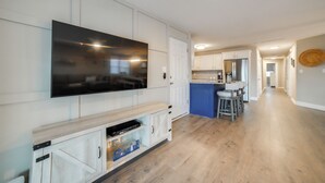 Cozinha moderna com televisão de tela plana, armários de madeira e uma ilha azul.