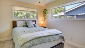 A bedroom with a bed, a ceiling fan, a nightstand, a wall-mounted plant, and windows. - Easy Access to Parks, Hospital: St Louis Home (St. Louis)