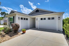 Eine Doppelgarage, an ein Haus mit geneigtem Dach und einer kleinen Veranda angebaut.