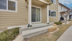 A residential building with a front porch, steps, and a window with blinds. - Home Near Air Force, Great Wolf, Ford Amphitheater (Colorado Springs)
