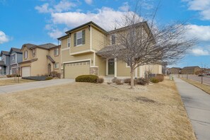 A two-story residential building with a front yard, a driveway, and a sidewalk. - Home Near Air Force, Great Wolf, Ford Amphitheater (Colorado Springs)
