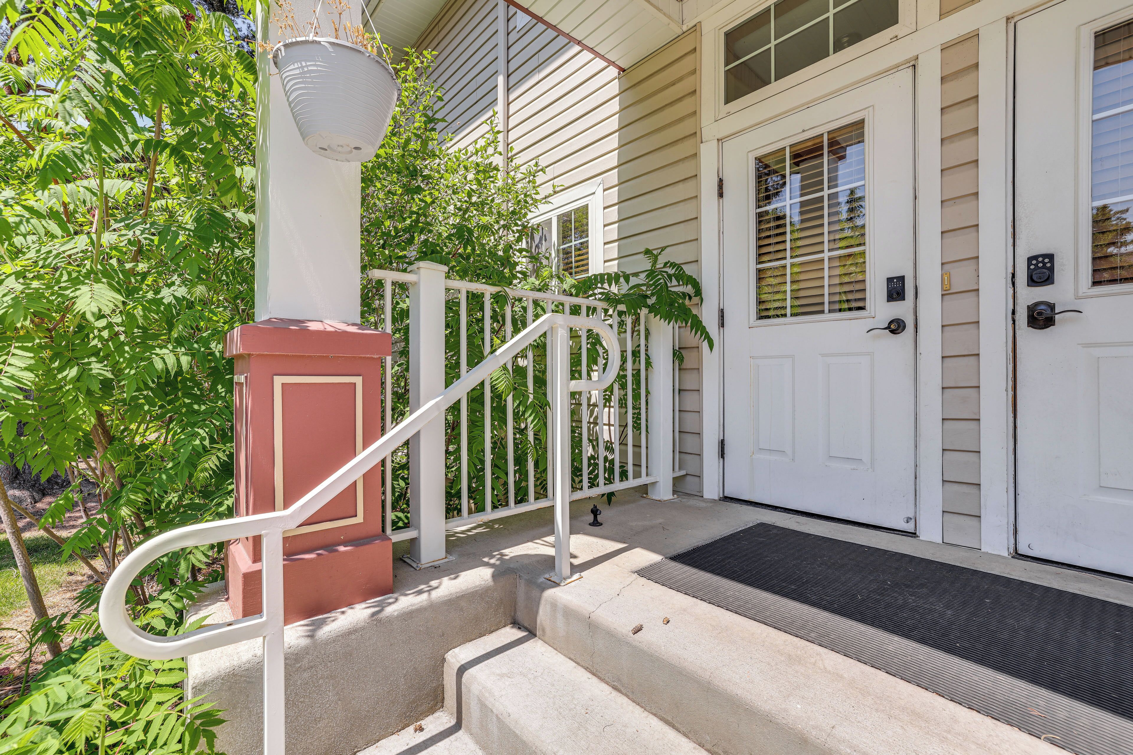 A house with a front porch, a white door, and a small staircase leading to the entrance.