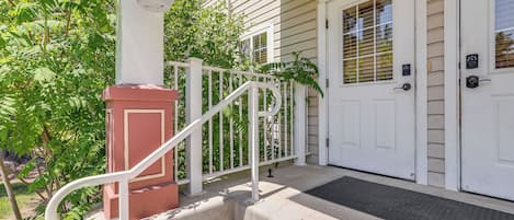 A house with a front porch, a white door, and a small staircase leading to the entrance.