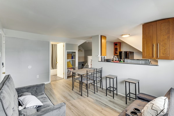 A modern apartment with a dining area, kitchen, and living space.