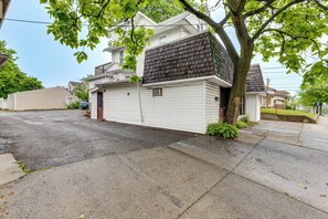 Ein Wohnhaus mit Garage und Baum vor der Tür, bewölkter Himmel.