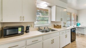 A kitchen with white cabinets, a microwave, a sink, and a dishwasher. - 2 Mi to Ft Sill: Home w/ Fenced Yard, Near Walmart (Lawton)