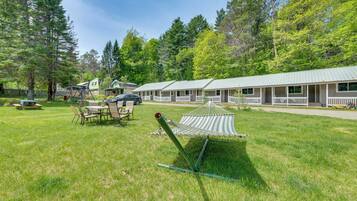 A campground with a hammock, picnic tables, and cabins.