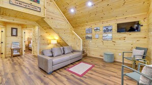 A wooden interior with a sofa, chairs, a TV, and framed pictures on the walls. - Tranquil 'red Magnolia Cabin' Near Lake Granbury! (Granbury)