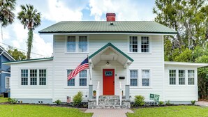 A white house with a red door, a flag, and a welcome sign. - Walk to Stetson and Historic Downtown Deland! (DeLand)