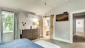 A bedroom with a bed, dresser, lamp, and a sliding door leading to another room. - Walk to Stetson and Historic Downtown Deland! (DeLand)