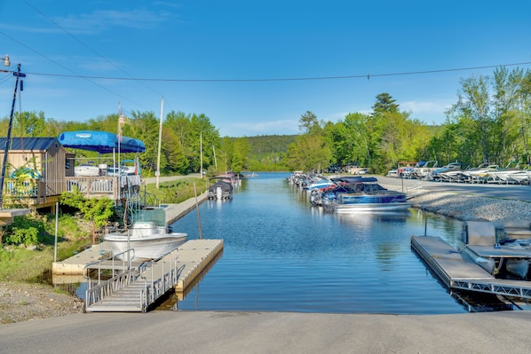 A marina with boats docked, a dock with a covered area, and a small building.