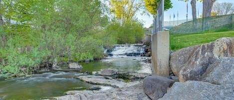 A natural landscape with a small waterfall, rocks, and trees.