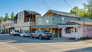 A street with parked cars, a building with a sign for a department store, and another building with a pink facade. - Close to Marina, Beach & Town! Schroon Lake Escape (Schroon Lake)