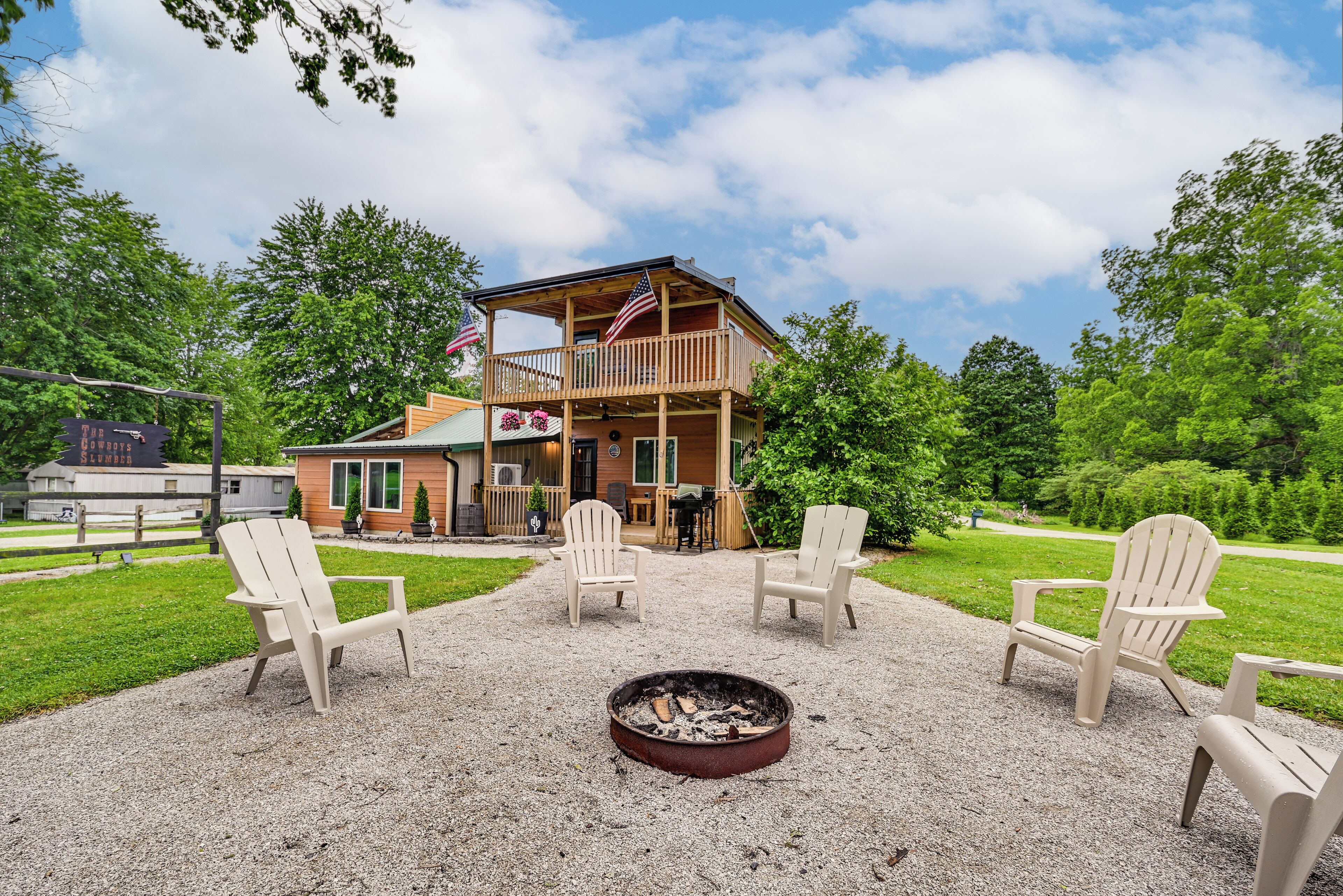 A lodge with a fire pit, outdoor seating, and a covered deck.