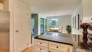 A kitchen with a refrigerator, white cabinets, a dining area with a table and chairs, and a large window. - Sunroom & Deck! Golf Retreat in Keowee Key (Salem)