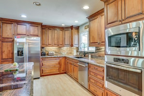 A kitchen with wooden cabinets, stainless steel appliances, granite countertops, and a built-in oven. - Palo Cedro Family Retreat: Pool, Nat'l Park, Lakes (Palo Cedro)