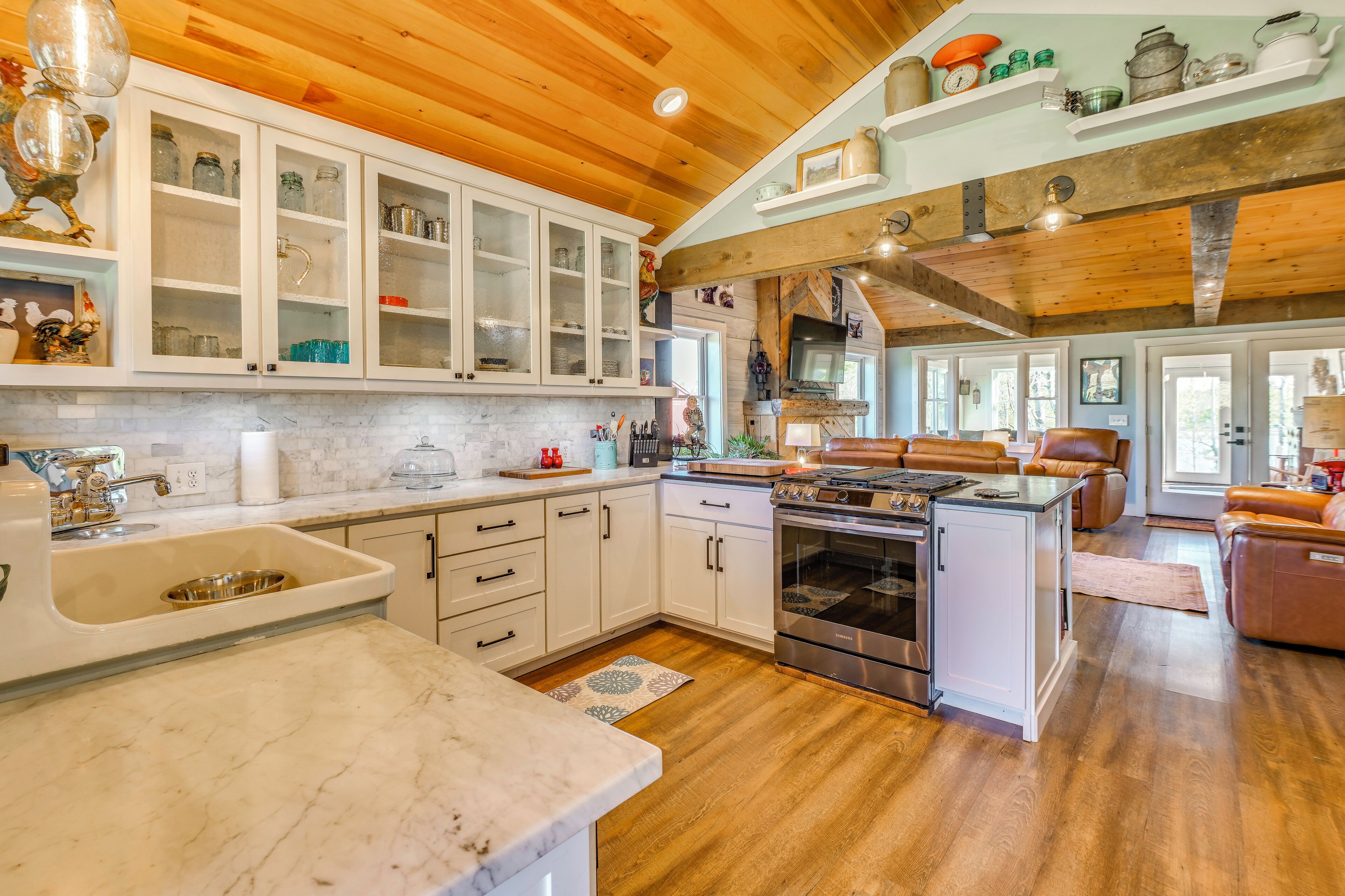 A kitchen with white cabinets, a sink, and a stove.
