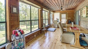A wooden cabin interior with large windows, a wooden ceiling, and a dining area. - Private Family Home w/ Ocoee River Access (Benton)
