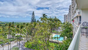 A hotel balcony with a view of a swimming pool, lush greenery, and a distant coastline. - Pool Access, 1 Mi to Makaha Beach! Ocean-view Unit (Waianae)