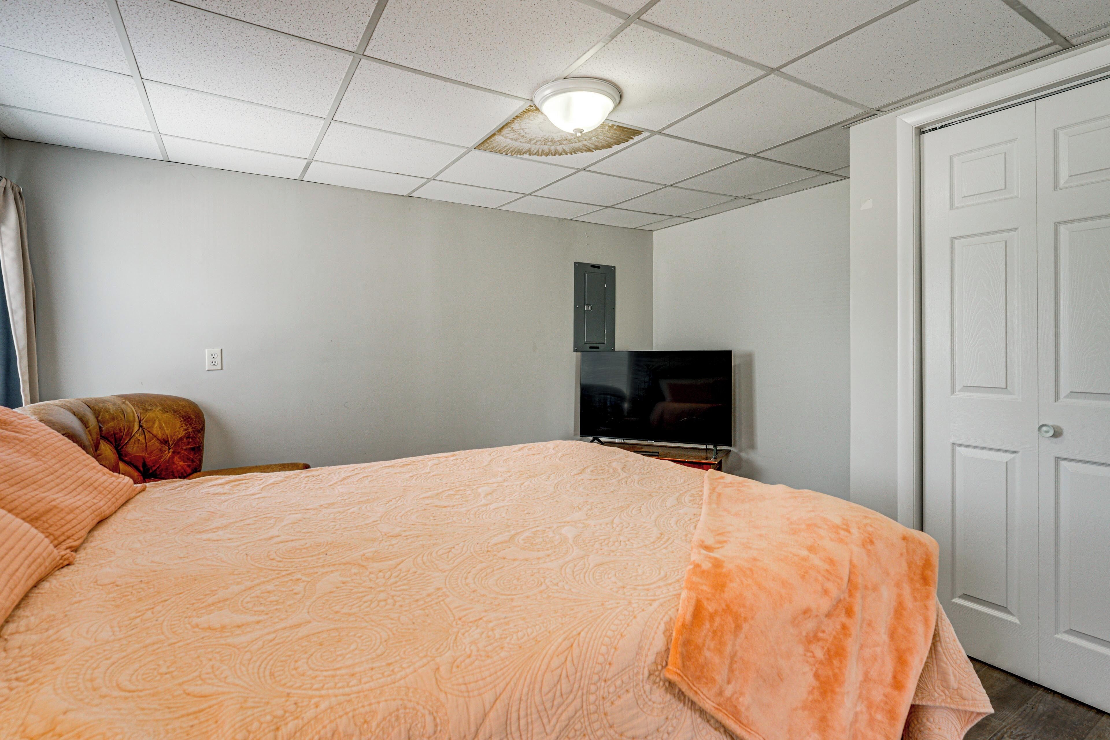 Une chambre à coucher avec un lit, une télévision, une armoire et une porte.