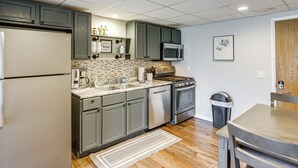 A kitchen with a refrigerator, microwave, stove, and sink. - Fish, Swim + Relax: Modern Condo by Lake Huron! (Port Huron)