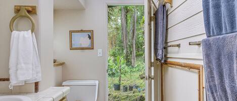 A bathroom with a toilet, sink, and towel rack.