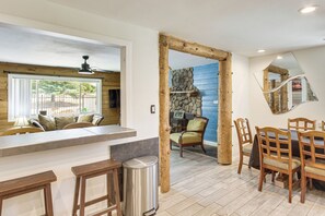 Una cocina moderna con barra, pared de piedra y mobiliario de madera.