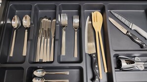 A drawer with compartments containing various utensils and cutlery. - Cangas with charm (Cangas)