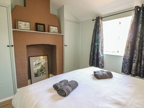 Ein Schlafzimmer mit Bett, Kamin und Vorhängen.