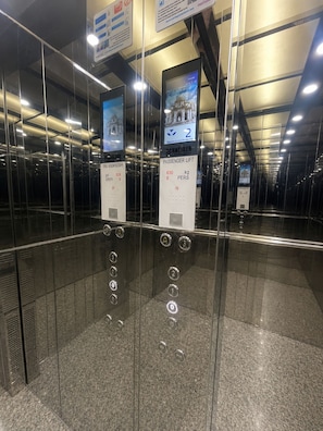 An elevator interior with glass walls, digital displays, and floor indicators. - sandra 20 F 27 (Marsa)