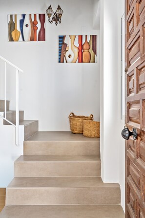 Eine Treppe mit einer Holztür und Wandbildern.