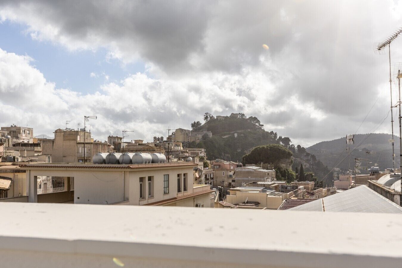 Un paisaje urbano con edificios, una colina y un cielo nublado.