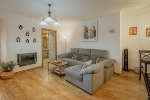 Una sala de estar con sofá, chimenea, mesa de centro y lámpara.