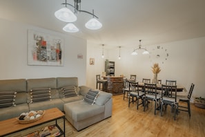 Una sala de estar con sofá, mesa de comedor, sillas y una mesita de centro.