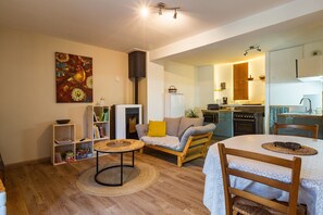 Un salon chaleureux avec un canapé, une petite table ronde et une bibliothèque.