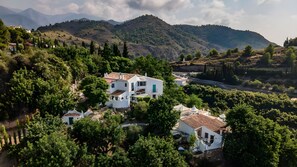 Una propiedad en una ladera con edificios blancos, una carretera y vegetación circundante.