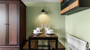 A dining area with a wooden table set for six, a cabinet, and a wall-mounted radiator. - Marina Haven Sea Views Parking By My Getaways (Brighton)