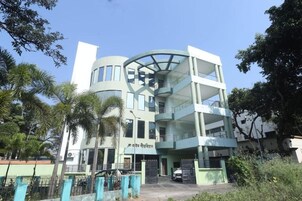 Un edificio de varios pisos con un atrio central, varios balcones y una entrada protegida por una reja.