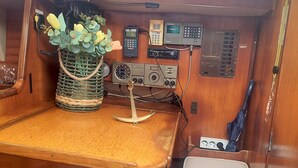 Puisesti sisustettu tila, jossa on pöytä, pieni oleskelualue, seinälle asennettu radio ja koristeellinen kasvi.