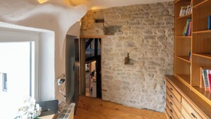 A room with a stone wall, wooden bookshelf, and a door leading to another room. - Wonderful private villa for 10 guests with TV and terrace (Rittersdorf)
