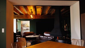 A cozy living room with a fireplace, leather sofa, and a dining table. - Charming Holiday Home 'Les Griottes Gîte de Charme' with Indoor Pool (Verdigny)