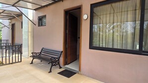 A building with a bench outside, a door, and a window with a curtain. - Perfect 10-bedroom hotel with AC in lovely Chennai (Chennai)