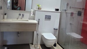 A modern bathroom with a toilet, sink, and shower area. - Perfect 10-bedroom hotel with AC in lovely Chennai (Chennai)