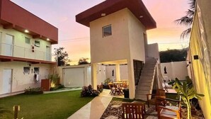 A modern building with a flat roof, a staircase, and outdoor seating. - Residencial 220 Maresias (São Sebastião)