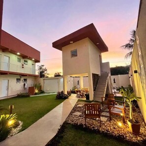 A modern building with a flat roof, a staircase, and outdoor seating. - Residencial 220 Maresias (São Sebastião)