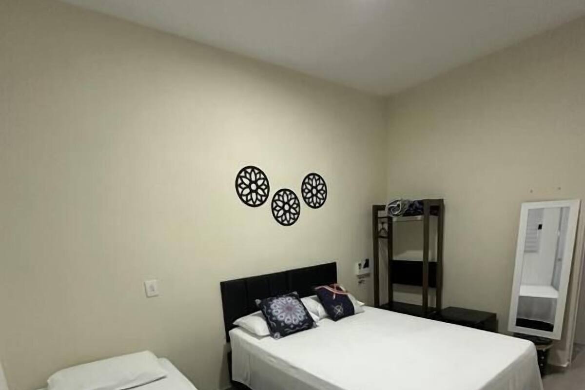 Een hotelkamer met twee bedden, een garderobe, een spiegel en decoratieve wandkunst.