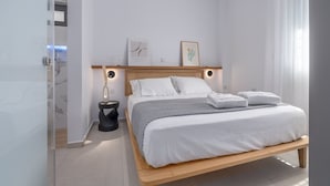 Ein modernes Schlafzimmer mit einem Bettgestell aus Holz, weißer Bettwäsche und zwei Wandleuchten.