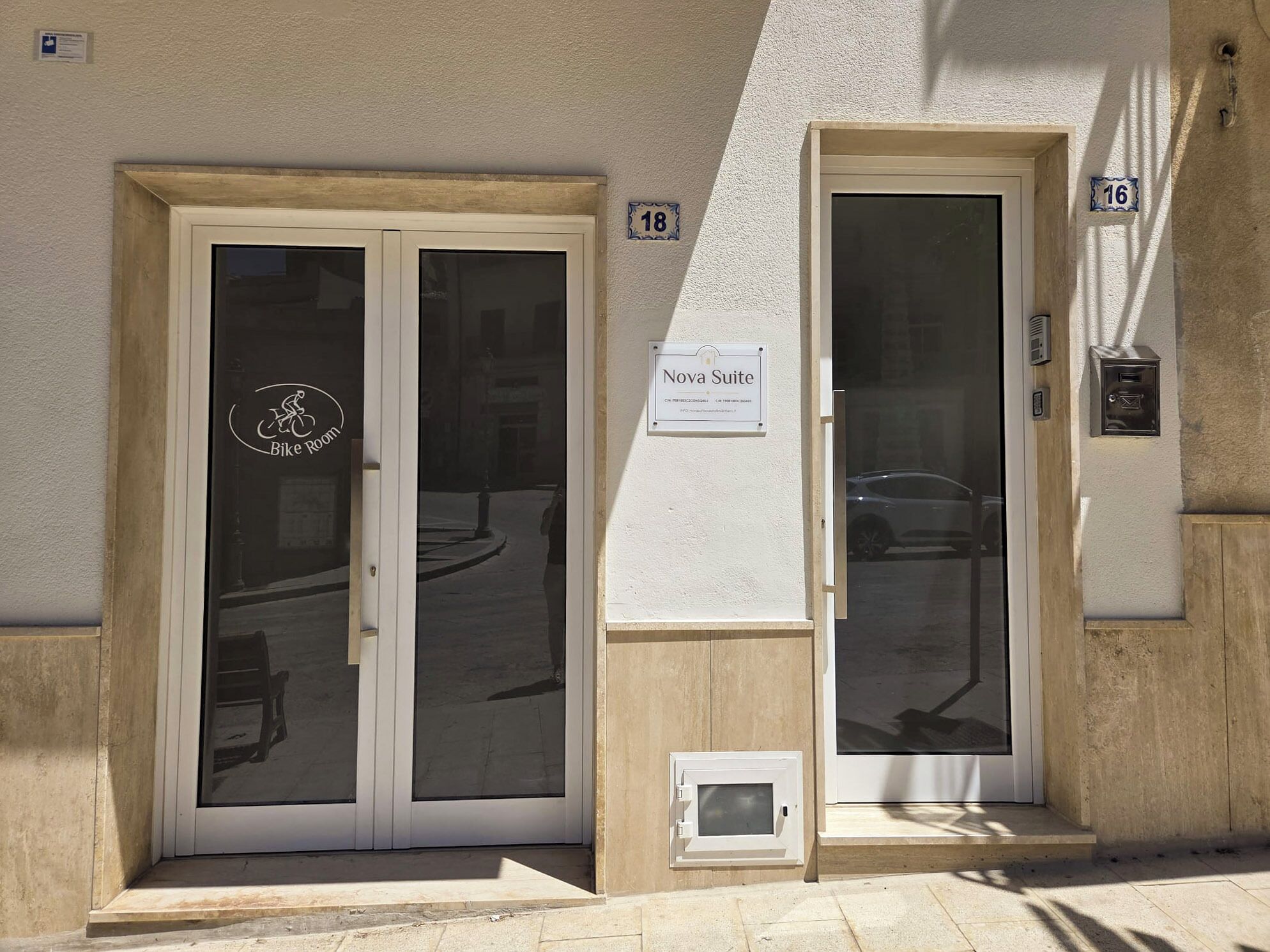 A building entrance with two doors, one labeled 'Bike Room' and the other 'Nova Suite.'