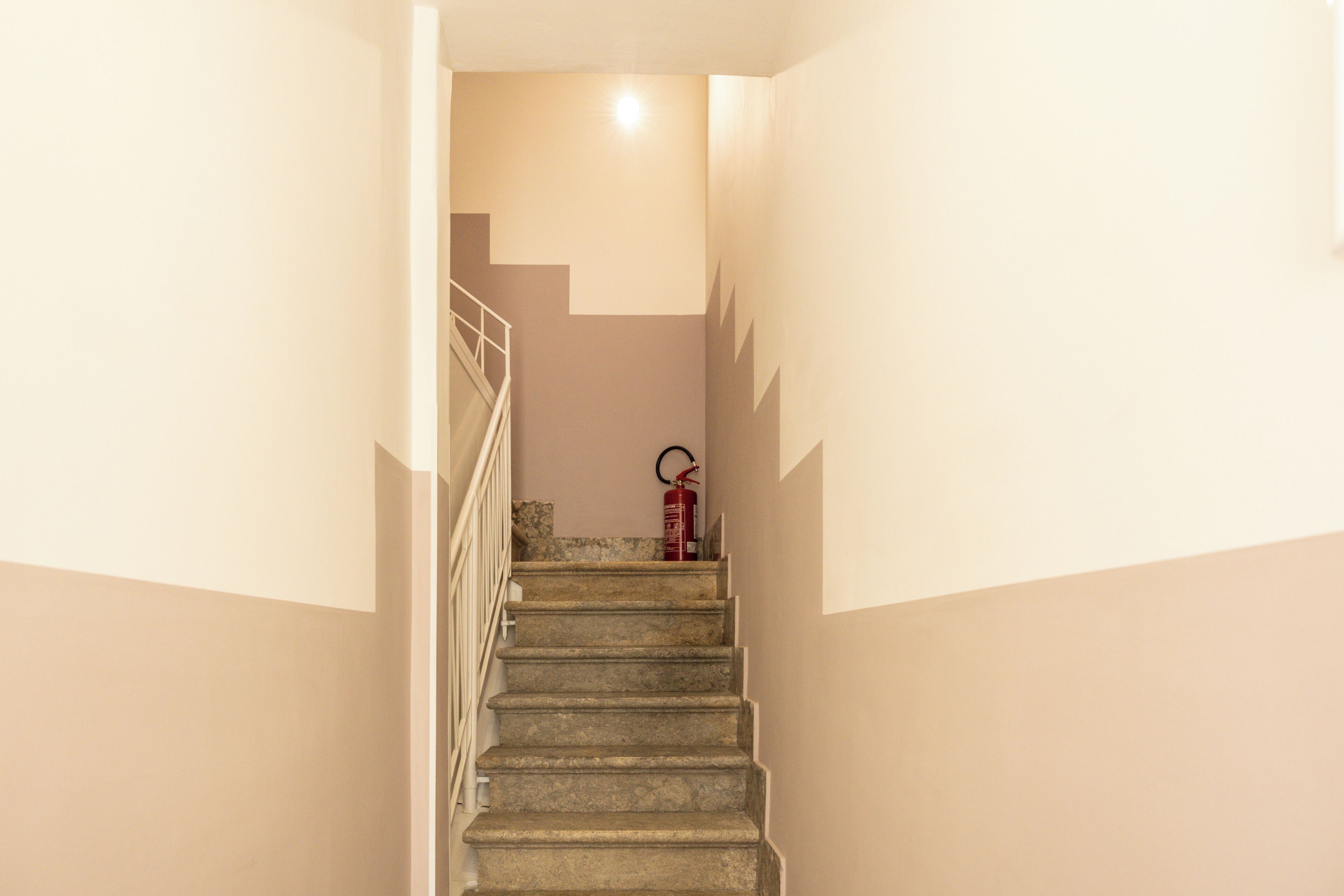 A staircase with a fire extinguisher mounted on the wall.