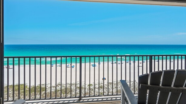 Un balcon avec vue sur une plage et l’océan.
